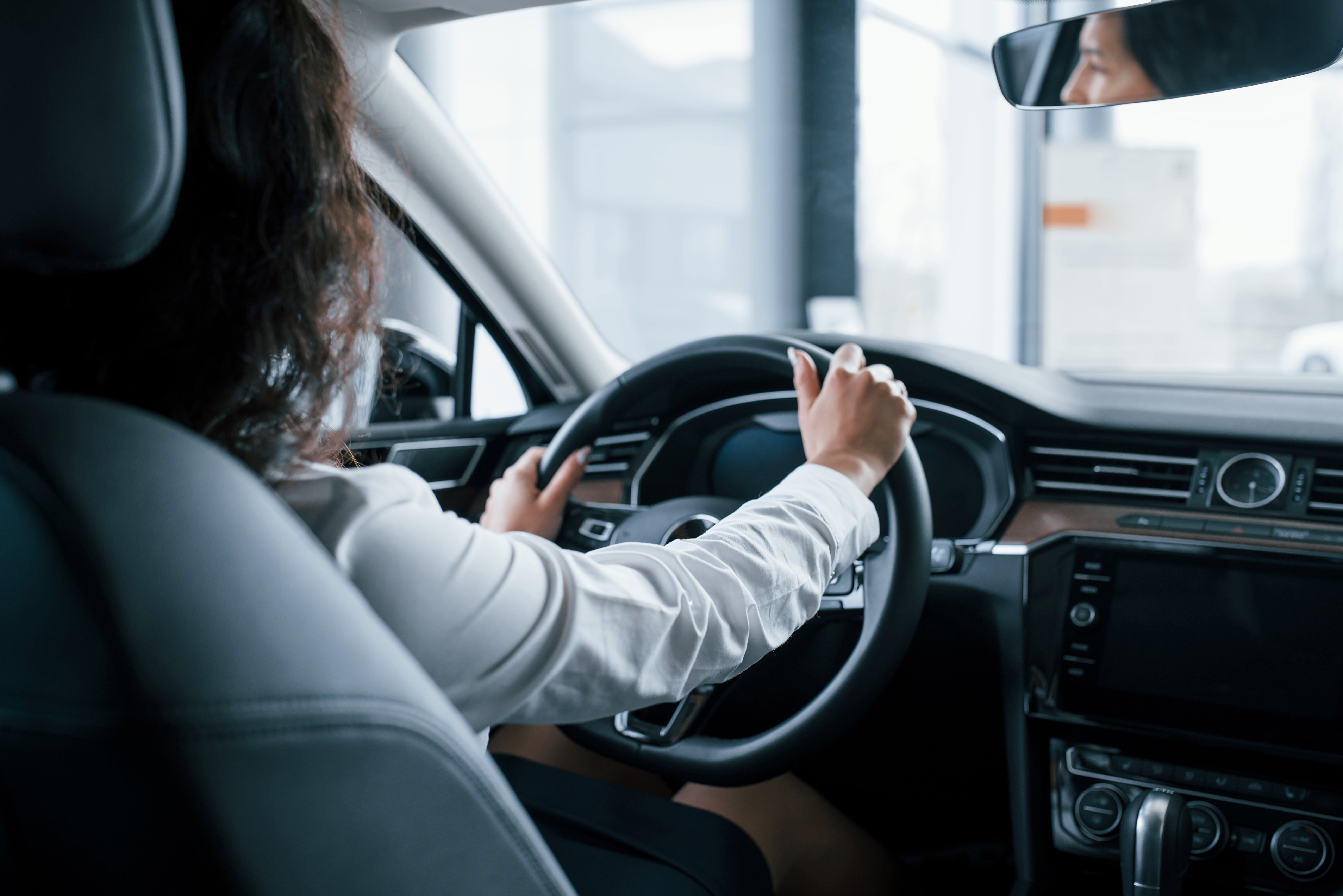 hands-steering-wheel-beautiful-businesswoman-trying-her-new-car-automobile-salon-min